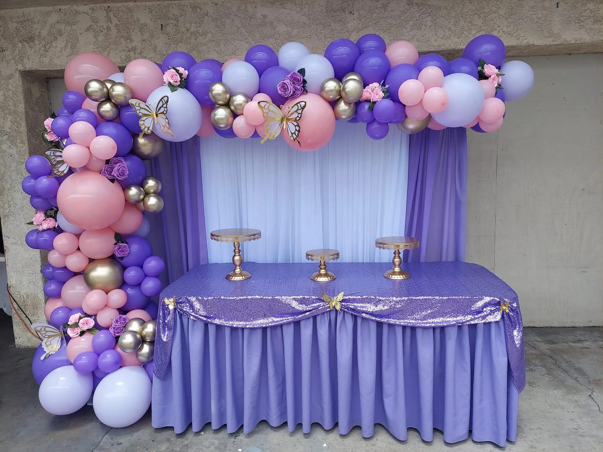 Purple and white balloon backdrop with table